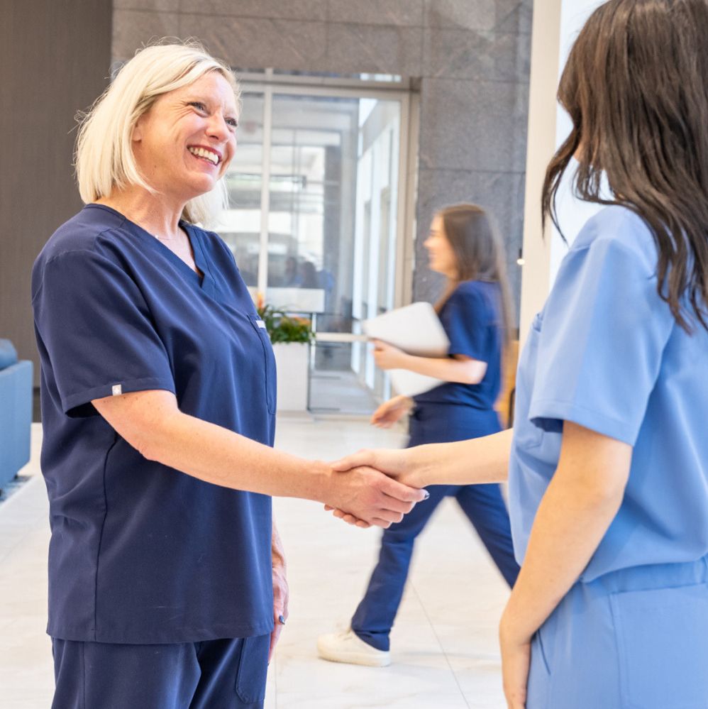 Women healthcare workers smiling and shaking hands