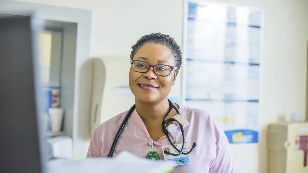 Nurse in an office smiling into camera