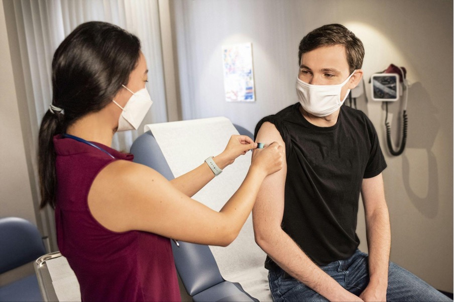 Nurse placing bandaid on patients arm