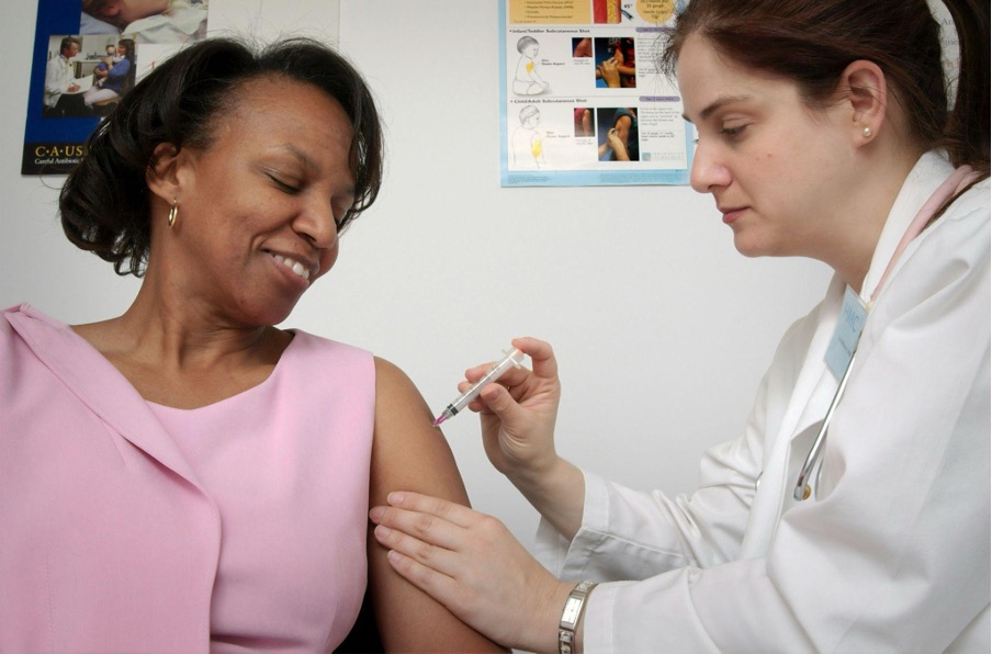 Female nurse giving patient a shot