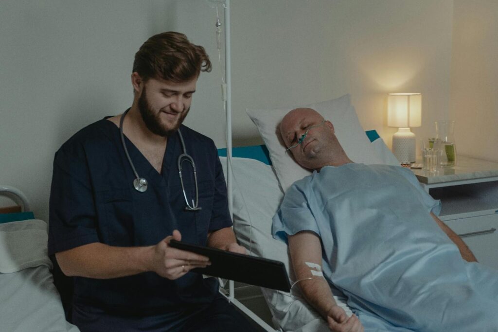 Nurse assisting patient in hospital bed.