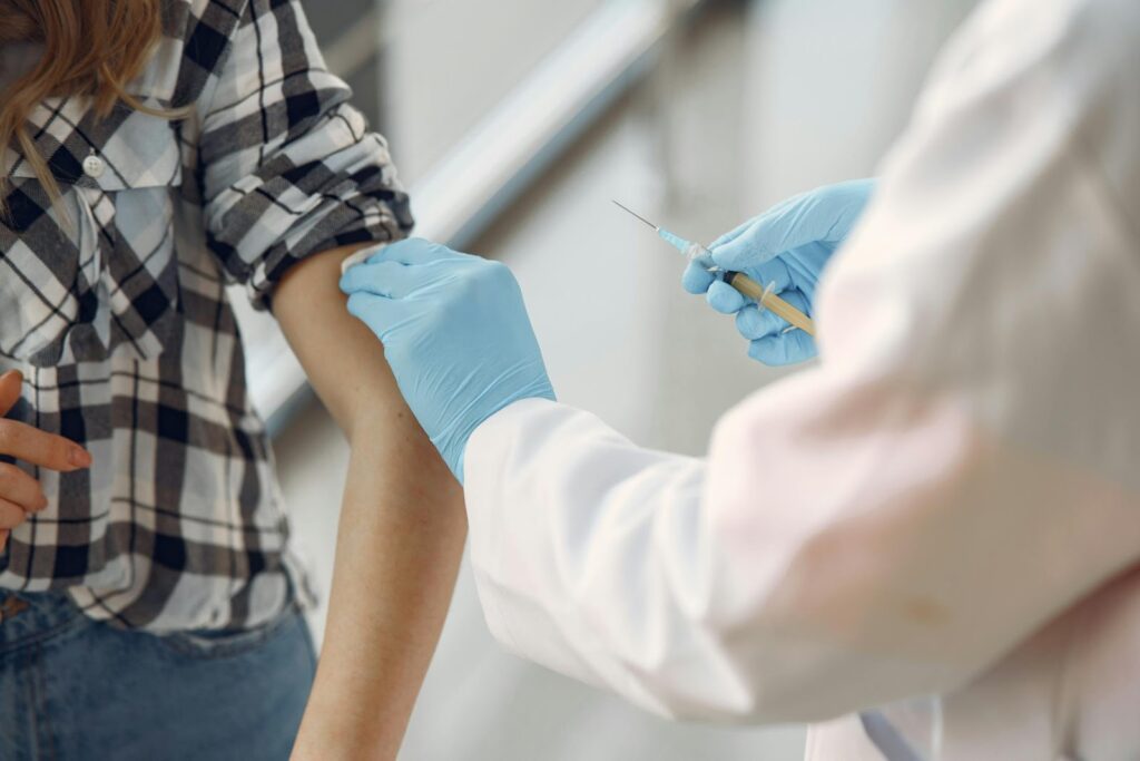 Nurse administering medicine to a patient via injection