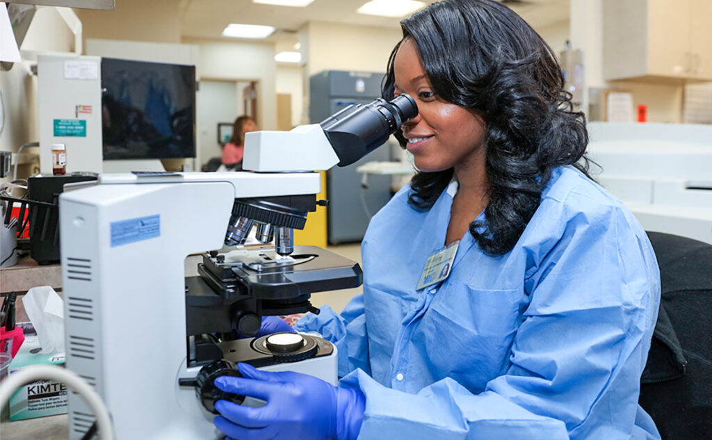 African American student in laboratory using microscope