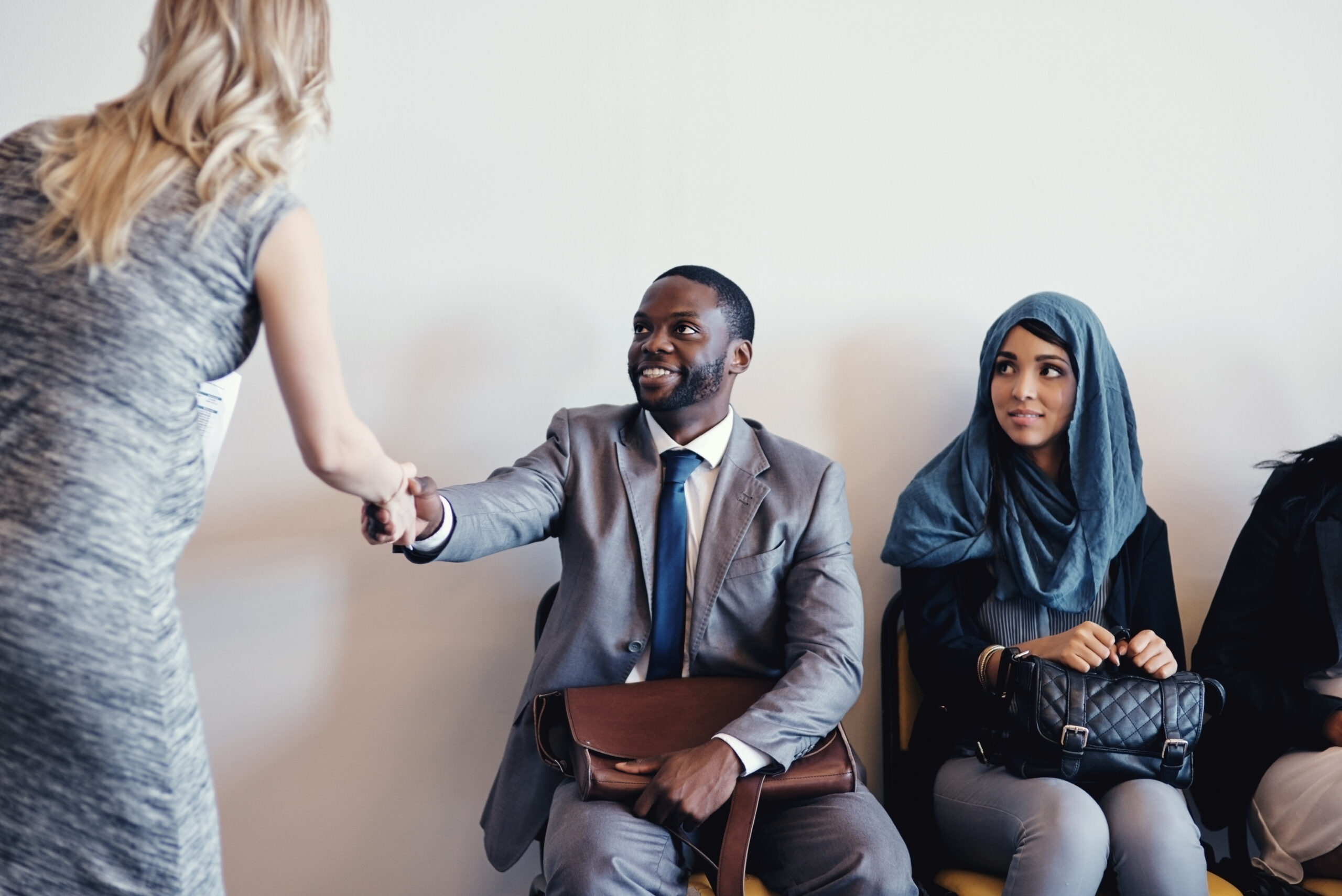 Man shaking female interviewer's hand in a waiting room