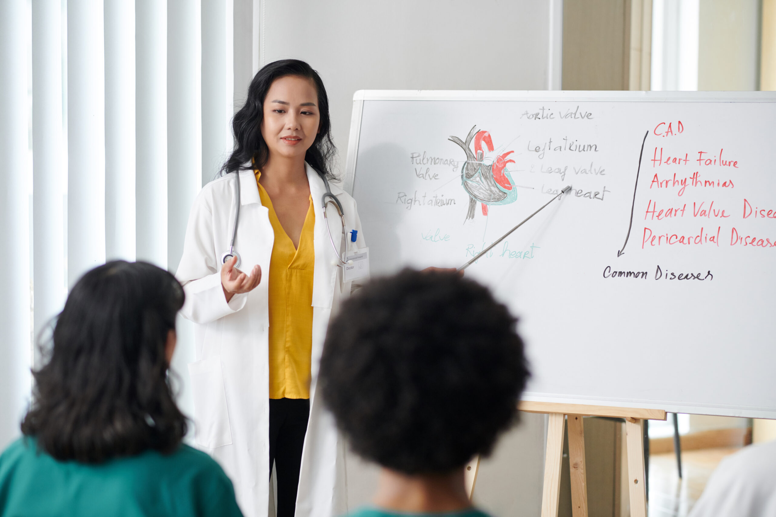 Female nurse giving lesson to residents on whiteboard