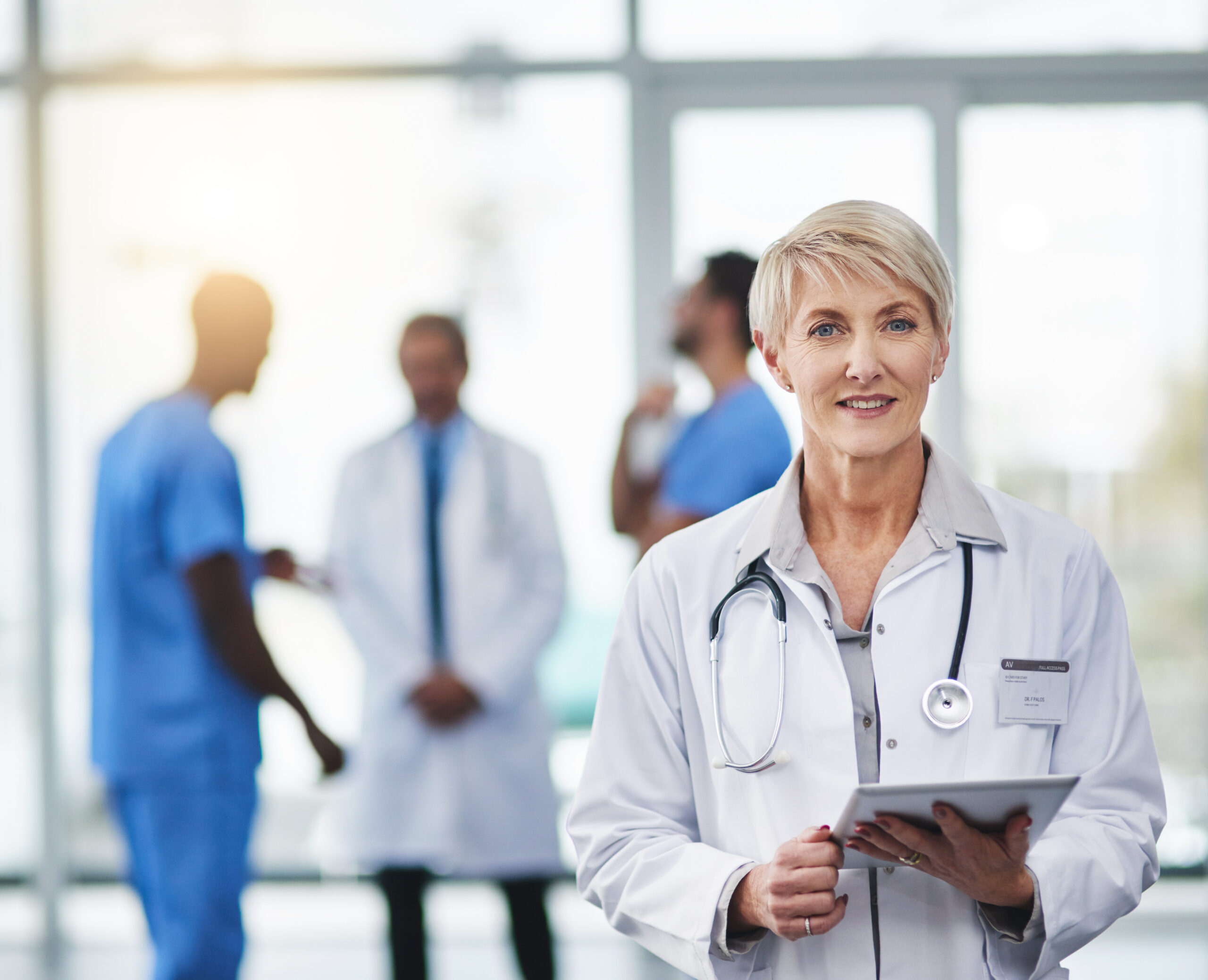 Female doctor smiling in camera holding clipboard