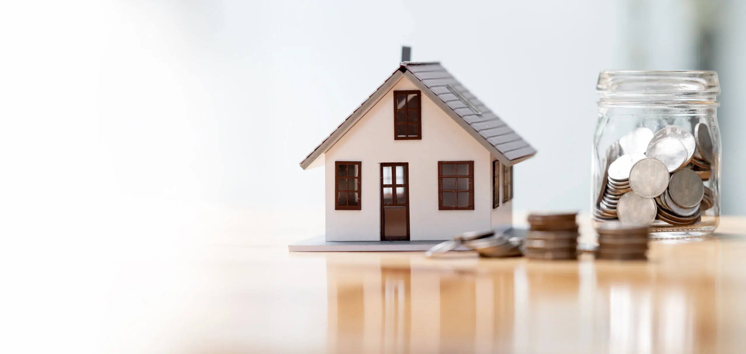 Picture of a model home with a jar of change to the right of it
