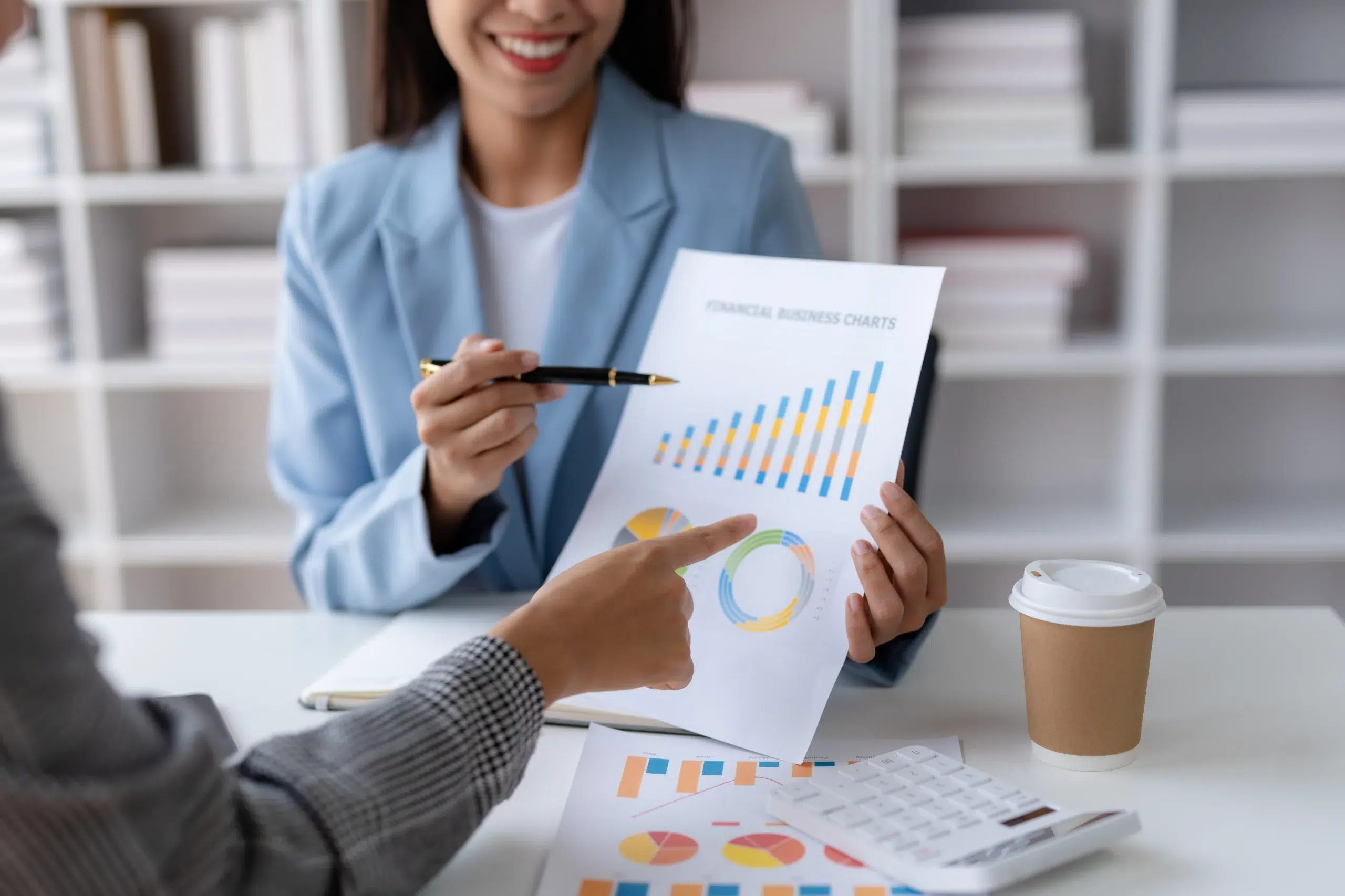 Woman explaining a graph on paper to another person.